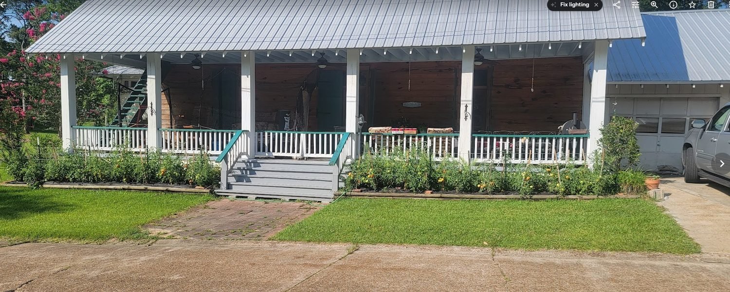 The long front porch of Le Maison Deslatte under its tin roof