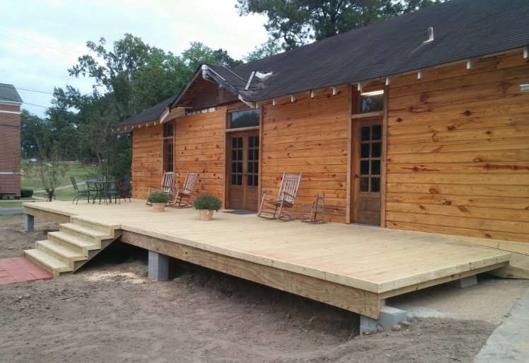 The newly built porch deck in fresh wood awaiting its roof