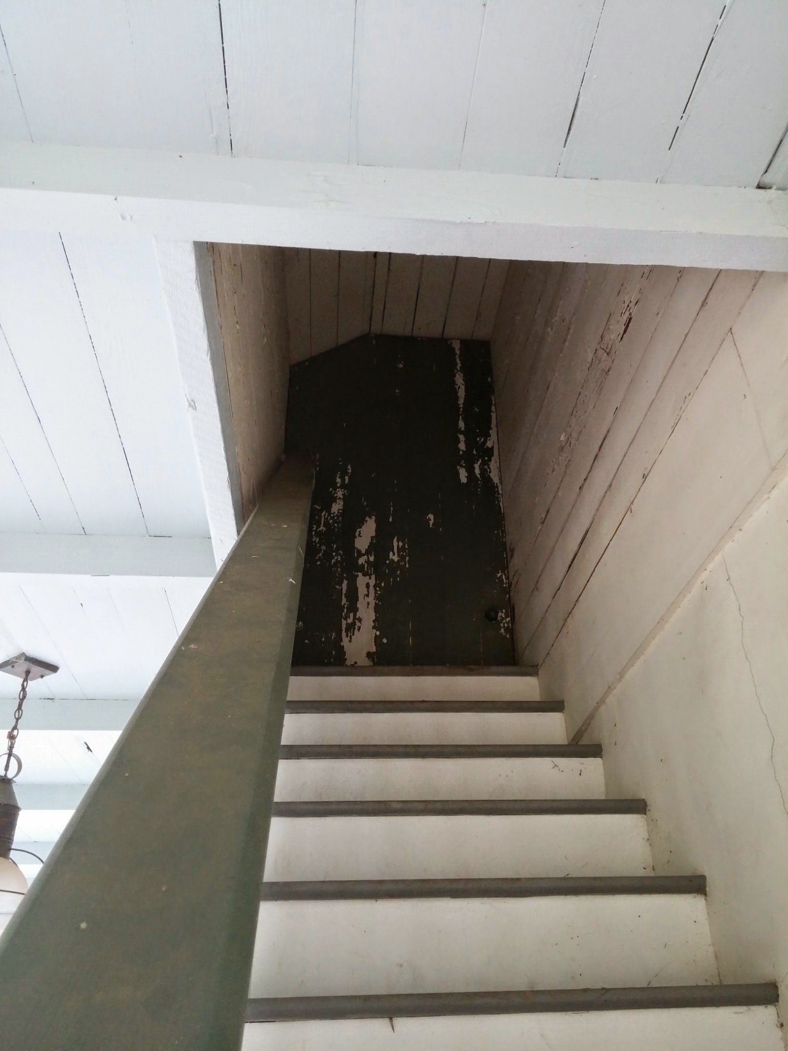 An outside staircase rising along a porch wall to a loft