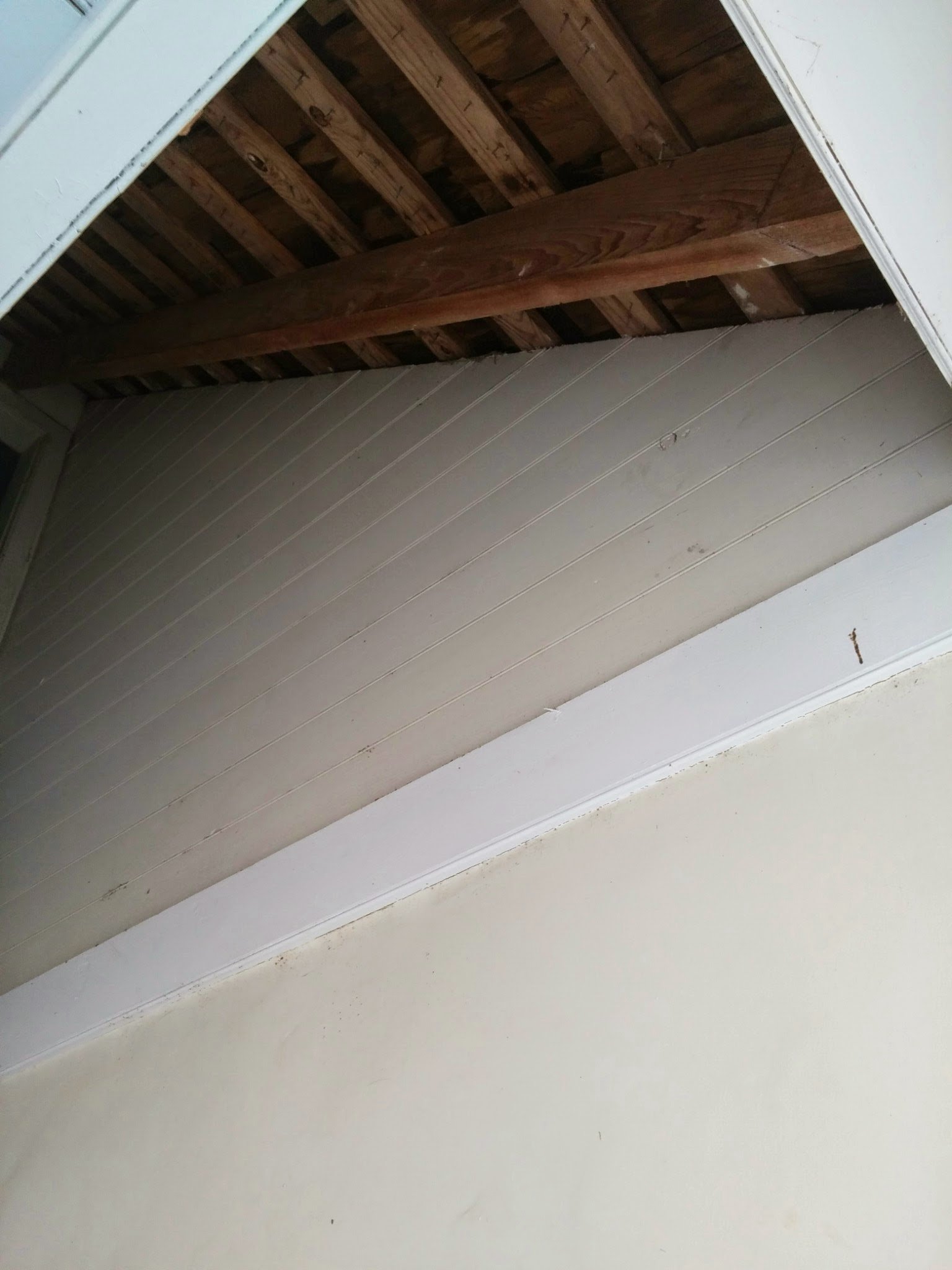 Exposed cypress rafters beneath a porch roof