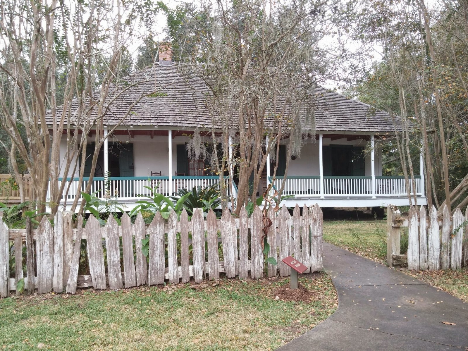 An Acadian cottage behind a picket fence